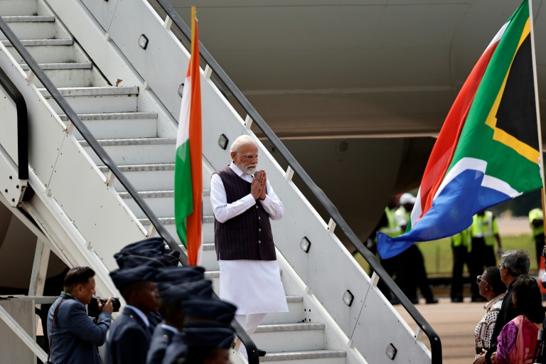 Le Premier ministre indien Narendra Modi réagit à son arrivée à la base aérienne de Waterkloof à Pretoria, le 21 novembre 2025, à la veille d'un sommet des dirigeants du G20 en Afrique du Sud