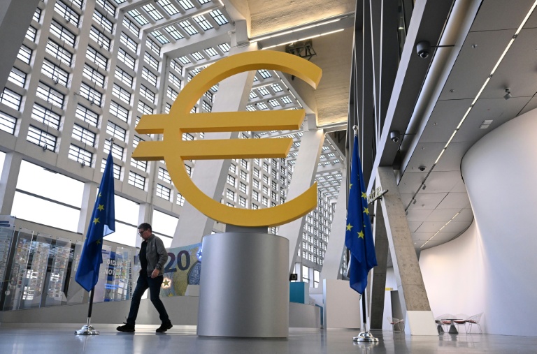 Un homme marche près du logo de la Banque centrale européenne au sein de son siège, le 18 décembre 2025 à Francfort en Allemagne