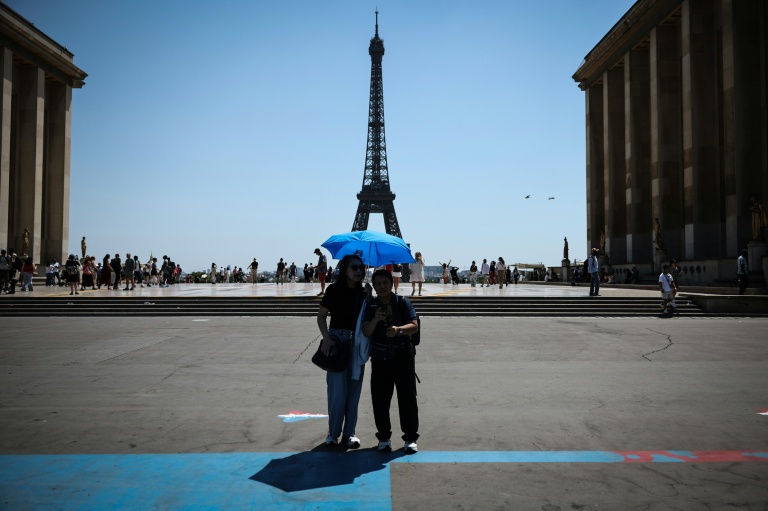 Des touristes se protègent du soleil au Trocadéro à Paris, le 18 juin 2026