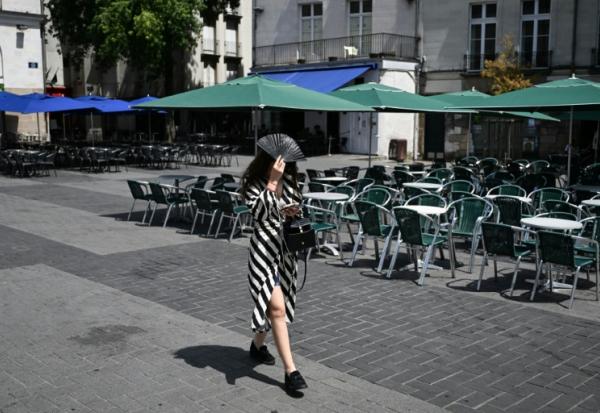 Une passante se protège du soleil avec un éventail, le 23 juin 2026 à Nantes