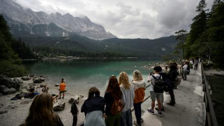 Des touristes admirent la vue du lac Eibsee, près de Garmisch-Partenkirchen, dans le sud de l'Allemagne, le 22 août 2025 