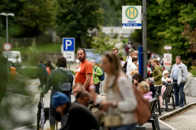 Des touristes autour d'un arrêt de bus près du lac Eibsee, près de Garmisch-Partenkirchen, dans le sud de l'Allemagne, le 22 août 2025