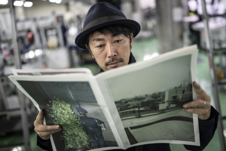 Le photographe Kazuma Obara regarde son œuvre 