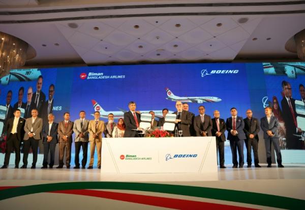Photo diffusée par Biman Bangladesh Airlines montrant le PDG de compagnie aérienne, Kaizer Sohel Ahmed (g), et le vice-président de Boeing, Paul Righi (d), échangeant des documents après la signature d'un accord à Dacca, le 30 avril 2026 au Bangladesh
