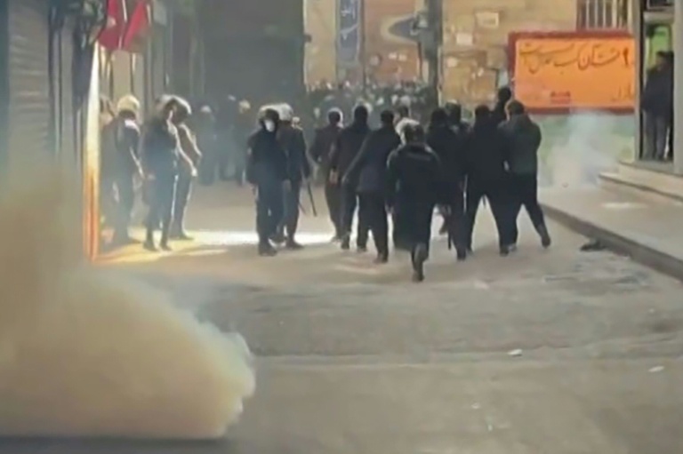 Cette capture d'une video UGC diffusée sur les réseaux sociaux montre des forces de l'ordre iraniennes dispersant des manifestants dans le Grand bazar de Téhéran le 6 janvier 2006