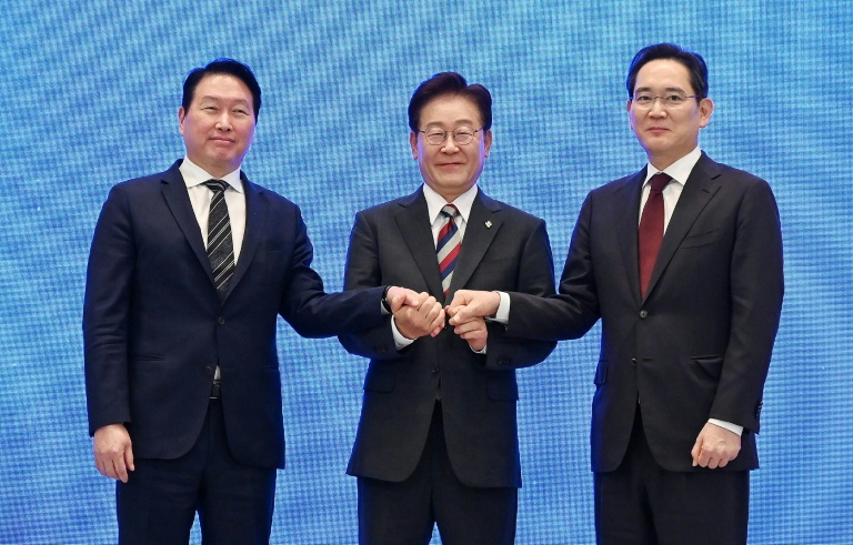 Le président Lee Jae Myung (c) scelle d'une poignée de main un plan public-privé de 1.200 milliards de dollars pour les puces et l'IA, à Séoul, le 29 juin 2026