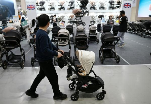Un homme avec sa poussette dans une allée d'un salon de l'enfant, le 30 avril 2026 à Séoul 