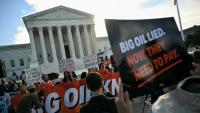 Des personnes manifestent pour dénoncer la contribution des compagnies pétrolières au changement climatique devant la Cour suprême des Etats-Unis, à Washington le 5 octobre 2026