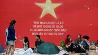 Des gens attendent et campent sur les trottoirs le 1er septembre 2025 à Hanoï avant le défilé militaire prévu mardi