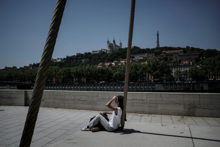 Une personne est assise sur les quais de la Saône, à Lyon, le 26 mai 2026, alors qu'une vague de chaleur frappe la France