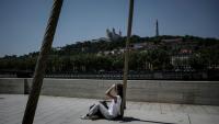 Une personne est assise sur les quais de la Saône, à Lyon, le 26 mai 2026, alors qu'une vague de chaleur frappe la France
