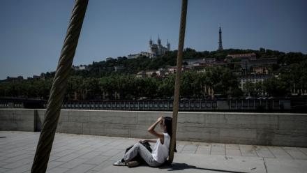 Une personne est assise sur les quais de la Saône, à Lyon, le 26 mai 2026, alors qu'une vague de chaleur frappe la France