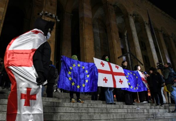Des manifestants brandissent les drapeaux de la Géorgie et de l'Union européenne lors de la vague de contestation qui a suivi les élections législatives de 2024, le 5 décembre 2024 à Tbilissi