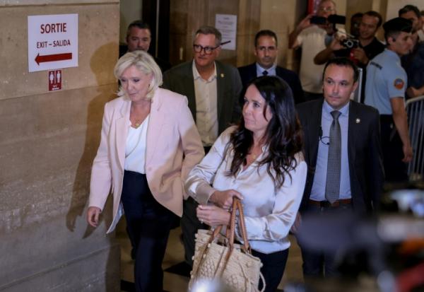 (g-d) La présidente du groupe parlementaire du Rassemblement national (RN), Marine Le Pen, le maire de Perpignan, Louis Aliot, et la députée européenne Catherine Griset arrivent pour assister au prononcé du verdict en appel concernant d'anciens et d'actuels membres du RN, poursuivis pour détournement de fonds publics européens dans l'affaire des emplois présumés fictifs au Parlement européen, à la cour d'appel de Paris, le 7 juillet 2026