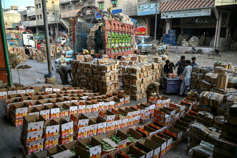 Des ouvriers chargent des caisses de mangues sur un camion à Karachi, le 5 juin 2026 au Pakistan