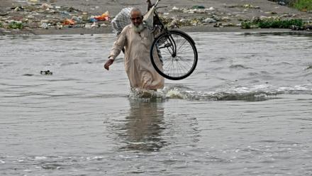 Un homme traverse une rue inondée de Karachi, mégapole du Pakistan où les pluies de mousson ont fait plus de 400 morts en une semaine, le 20 août 2025
