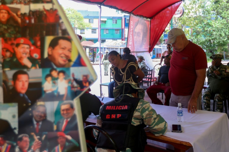 Des gens s'inscrivent pour rejoindre les forces militaires lors d'une campagne nationale d'enrôlement lancée par le président vénézuélien Nicolas Maduro, le 23 août 2025 à Caracas