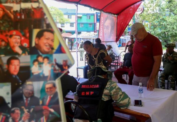 Des gens s'inscrivent pour rejoindre les forces militaires lors d'une campagne nationale d'enrôlement lancée par le président vénézuélien Nicolas Maduro, le 23 août 2025 à Caracas