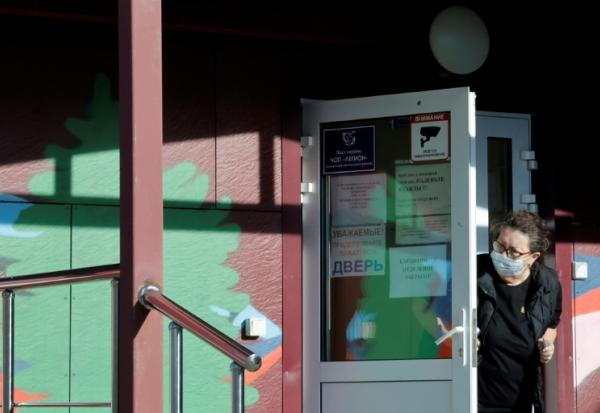 Une employée de la sécurité porte un masque de protection à l'entrée d'un hôpital spécialisé dans les maladies infectieuses à Chelekhov, dans la région d'Irkoutsk, le 7 octobre 2026 en Russie