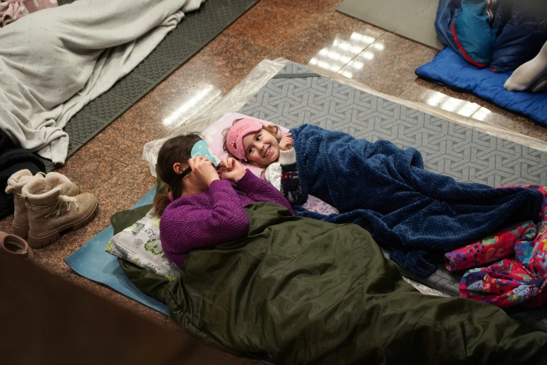 Une femme et un enfant se réfugient dans une station de métro pendant une attaque aérienne russe, à Kiev, tôt le matin du 3 février 2026, dans le contexte de l'invasion russe de l'Ukraine.