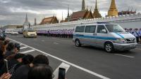 Des Thaïlandais assistent au passage du cortège funèbre amenant la dépouille de la reine mère Sirikit au Palais royal de Bankok, le 26 octobre 2025
