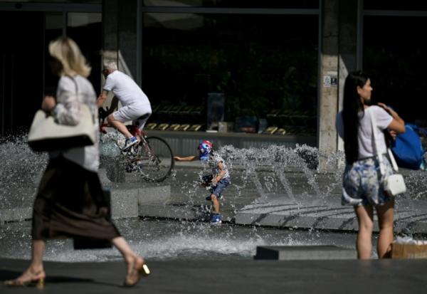 Un enfant se rafraîchit dans une fontaine à Belgrade, le 26 juin 2026 en Serbie, lors d'un épisode de canicule en Europe
