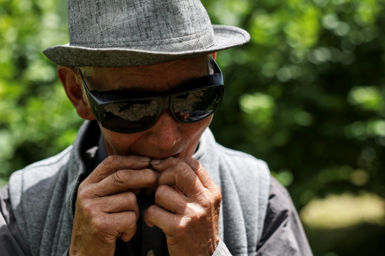 L'agriculteur bhoutanais Dawa Dhendup, 82 ans, casse une noisette, le 29 août 2026 dans son exploitation à Thimphou 