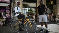 Deux livreurs à vélo se reposent pendant une vague de chaleur estivale près des restaurants en attendant des commandes, à Bordeaux, le 7 juillet 2026