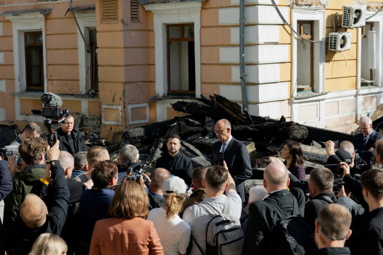 Le président ukrainien Volodymyr Zelensky (CG) et le chancelier allemand Friedrich Merz (CD) lors d'une visite du bâtiment endommagé de l'Académie des sciences de Kiev, le 4 octobre 2026 