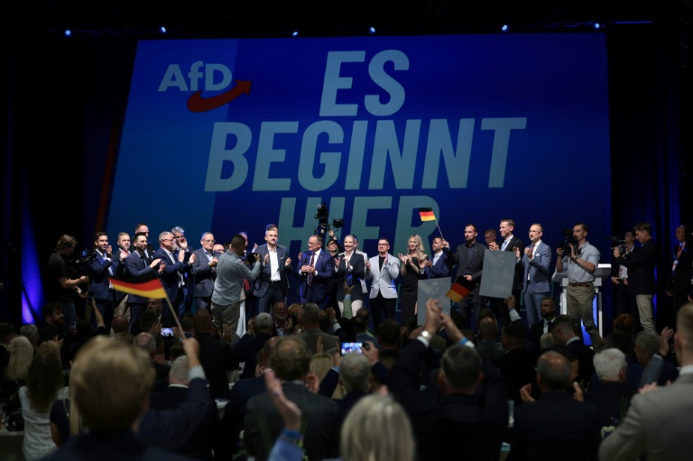 (g-d) Ulrich Siegmund, tête de liste du parti d'extrême droite Alternative pour l'Allemagne (AfD) aux élections régionales de Saxe-Anhalt, les coprésidents de l'AfD Tino Chrupalla et Alice Weidel et d'autres membres du parti chantent l'hymne national lors de la soirée électorale à Magdebourg, le 6 septembre 2026 dans l'est de l'Allemagne