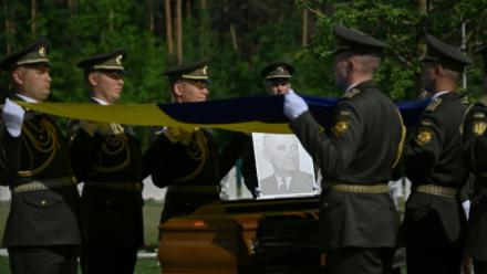 Des militaires de la garde d’honneur ukrainienne tiennent des drapeaux nationaux au-dessus des cercueils contenant les dépouilles d’Andriy Melnyk, mort en 1964 et chef d’une branche de l’Organisation des nationalistes ukrainiens (OUN) lors de leur cérémonie de réinhumation au cimetière militaire national près de Kiev, le 25 mai 2026