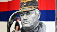 Un homme passe devant une fresque murale représentant l'ancien chef militaire des Serbes de Bosnie, Ratko Mladić, le 6 septembre 2026 à Belgrade, en Serbie, dont l'inhumation est prévue le 7 septembre 2026 au cimetière de Topčider à Belgrade, sur fond de critiques de l'UE concernant la "glorification" d'un criminel de guerre condamné pour génocide