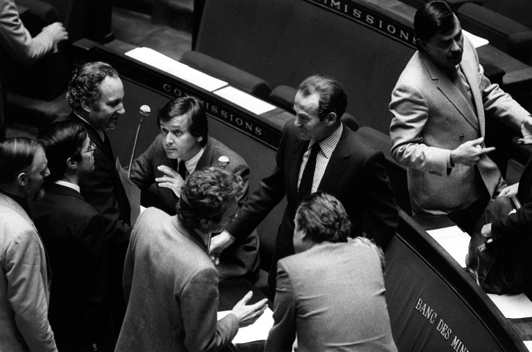 Des députés félicitent le ministre de la Justice Robert Badinter (c) dans l'hémicycle de l'Assemblée nationale après l'examen de son projet de loi sur l'abolition de la peine de mort, le 17 septembre 1981 à Paris