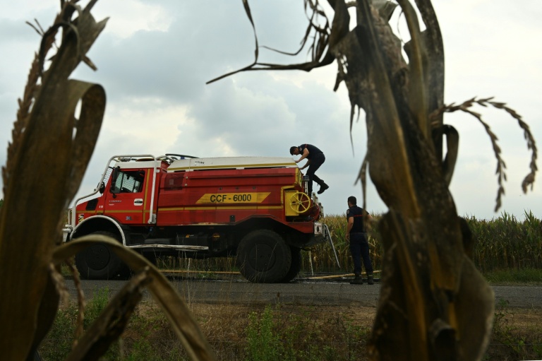 Des pompiers s'apprêtent à remplir leur citerne d'eau, le 16 août 2026 à Luglon, dans les Landes 