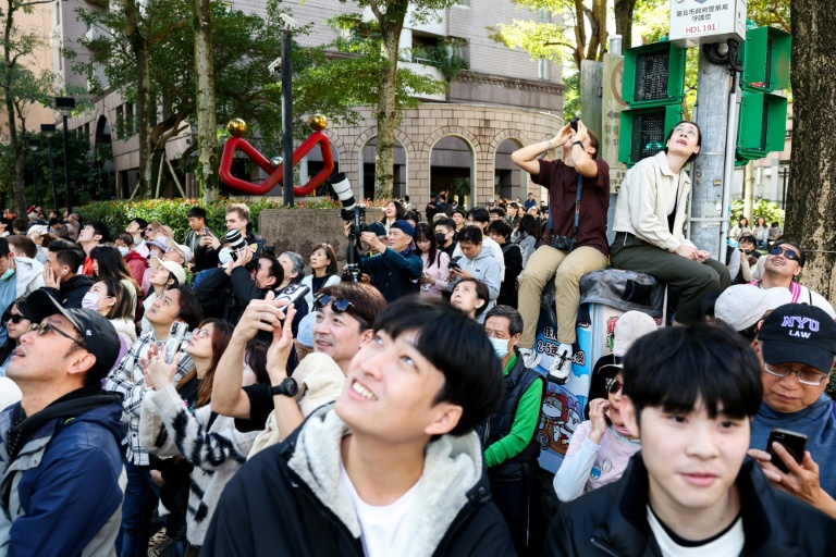 Des spectateurs suivent l'ascension, sans dispositif de sécurité, de la tour Taipei 101 par l'Américain Alex Honnold, le 25 janvier 2026