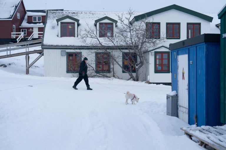 Une femme promène son chien dans le quartier du Vieux Nuuk, le 16 janvier 2026 à Nuuk, au Groenland