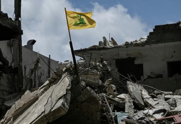 Le drapeau jaune du Hezbollah dans les décombres d'un bâtiment détruit par une frappe aérienne israélienne à Tyr, dans le sud du Liban, le 23 juin 2026