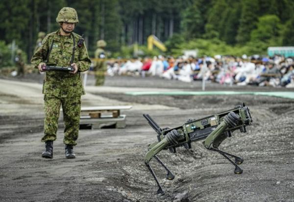 Un soldat de la Force terrestre d'autodéfense japonaise (JGSDF) manoeuvre un véhicule terrestre quadrupède sans pilote lors d'un exercice de tir réel dans la zone d'East Fuji, à Gotemba, le 7 juin 2026 au Japon