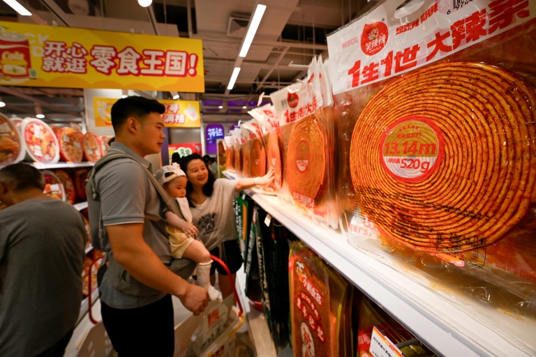 Des clients choisissent des lamelles épicées dans un marché à Changsha, dans la province du Hunan, le 17 juin 2026 dans le centre de la Chine