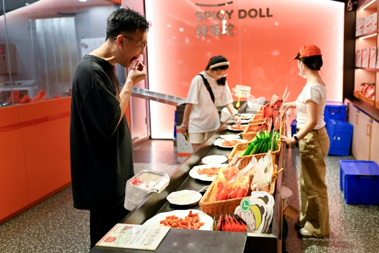 Des clients goûtent des lamelles épicées dans une boutique à Changsha, dans la province du Hunan, le 17 juin 2026 dans le centre de la Chine