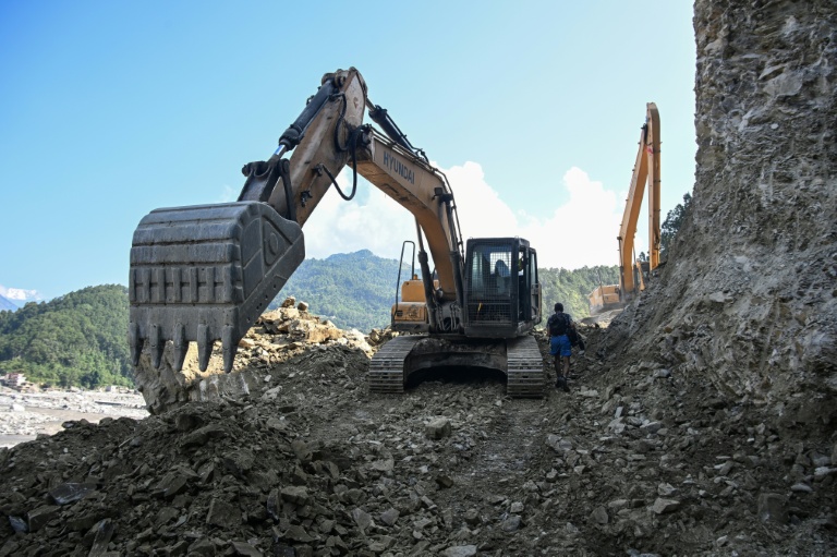 Des ouvriers dégagent une route avec des pelleteuses le long de la rivière Trishuli dans le district de Nuwakot, au Népal, le 1er octobre 2026