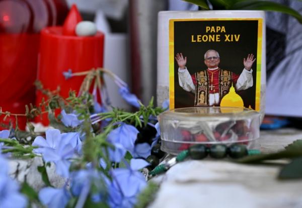 Des fleurs, des bougies et une photo du pape Léon XIV déposées au pied de la statue de Jean Paul II, devant l’hôpital Gemelli à Rome où le pape Léon XIV est en convalescence, le 17 octobre 2026
