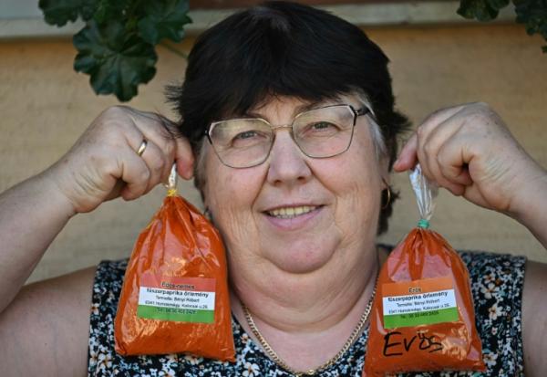 La cultivatrice Rozsa Benyi pose avec deux sachets de paprika devant son domicile à Homokmegy, dans le sud de la Hongrie, le 19 septembre 2026 