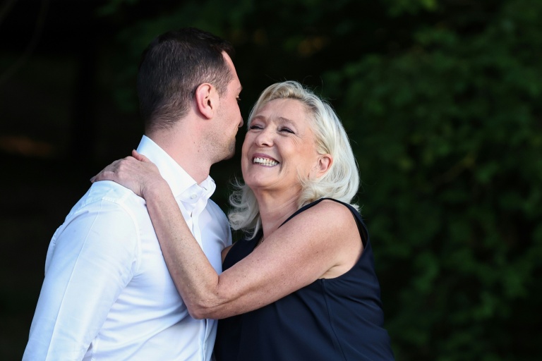 Le président du parti d’extrême droite français Rassemblement national (RN), Jordan Bardella (G), et la présidente du groupe parlementaire du Rassemblement national, Marine Le Pen, s’enlacent lors de leur participation à un événement du parti RN, à Liévin, dans le nord de la France, le 4 juillet 2026