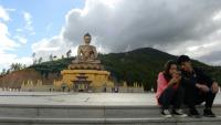 Un couple assis regarde l'écran d'un téléphone portable à côté d'une statue de Bouddha à Thimphou, la capitale du Bouthan, le  25 août 2018