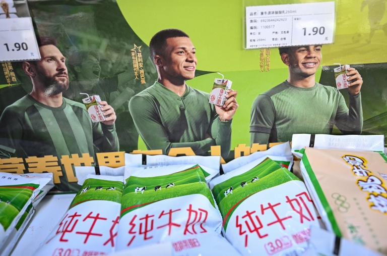 Les portraits des footballeurs Lionel Messi (g), Kylian Mbappé (c) et Lamine Yamal sur une affiche publicitaire de la marque de produits laitiers Mengniu, le 28 octobre 2026 dans un supermarché à Pékin