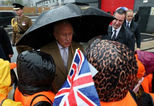 Charles III discute avec des écoliers lors d'une visite pour l'ouverture officielle d'un dépôt de métros à Taff’s Well au pays de Galles (Royaume-Uni), le 14 novembre 2025