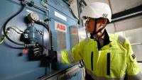 Guy Nicholson, responsable des solutions réseau neutres en carbone chez Statkraft, se tient près d'un volant d'inertie, le 7 août 2025 à Liverpool