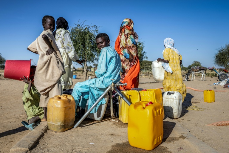 Des réfugiés soudanais remplissent des bidons d'eau, au camp de Tiné, au Tchad, le 10 novembre 2025