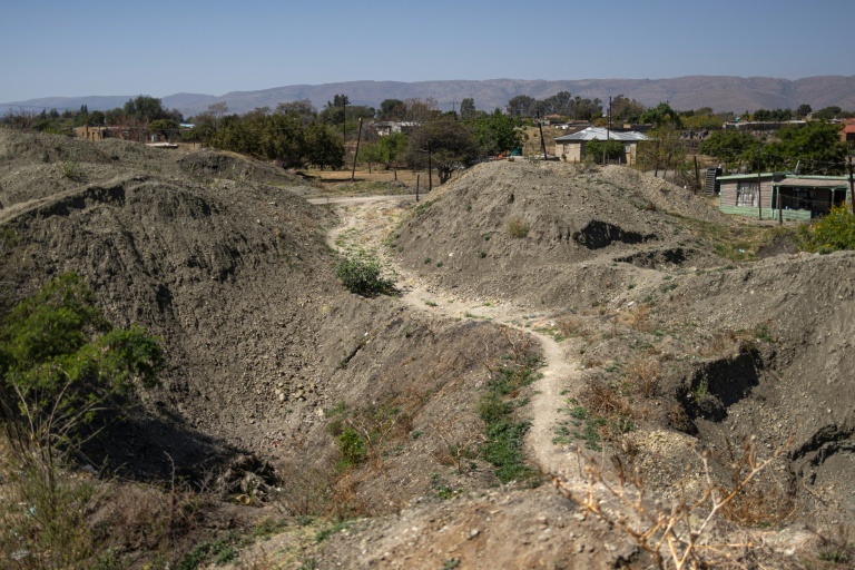 Un chemin passe entre des tas de terre extraits par des mineurs illégaux à la recherche de chrome à Bapong, un village minier de la province du Nord-Ouest (Afrique du Sud), le 25 août 2026